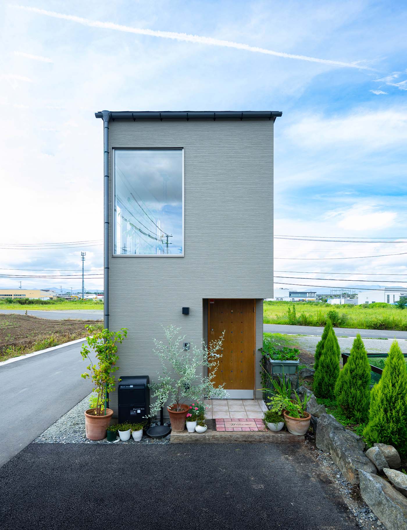 東側に設けた玄関側からの外観。木製の玄関ドアと2階の大きな窓が印象的