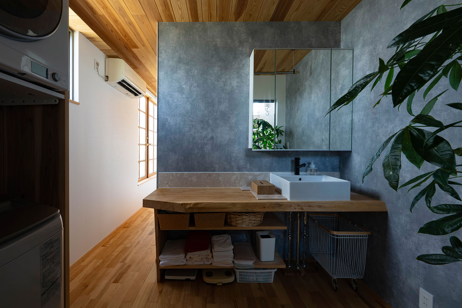 2階の奥に配した洗面脱衣室。カウンターは厚みのある一枚板を用いて造作した