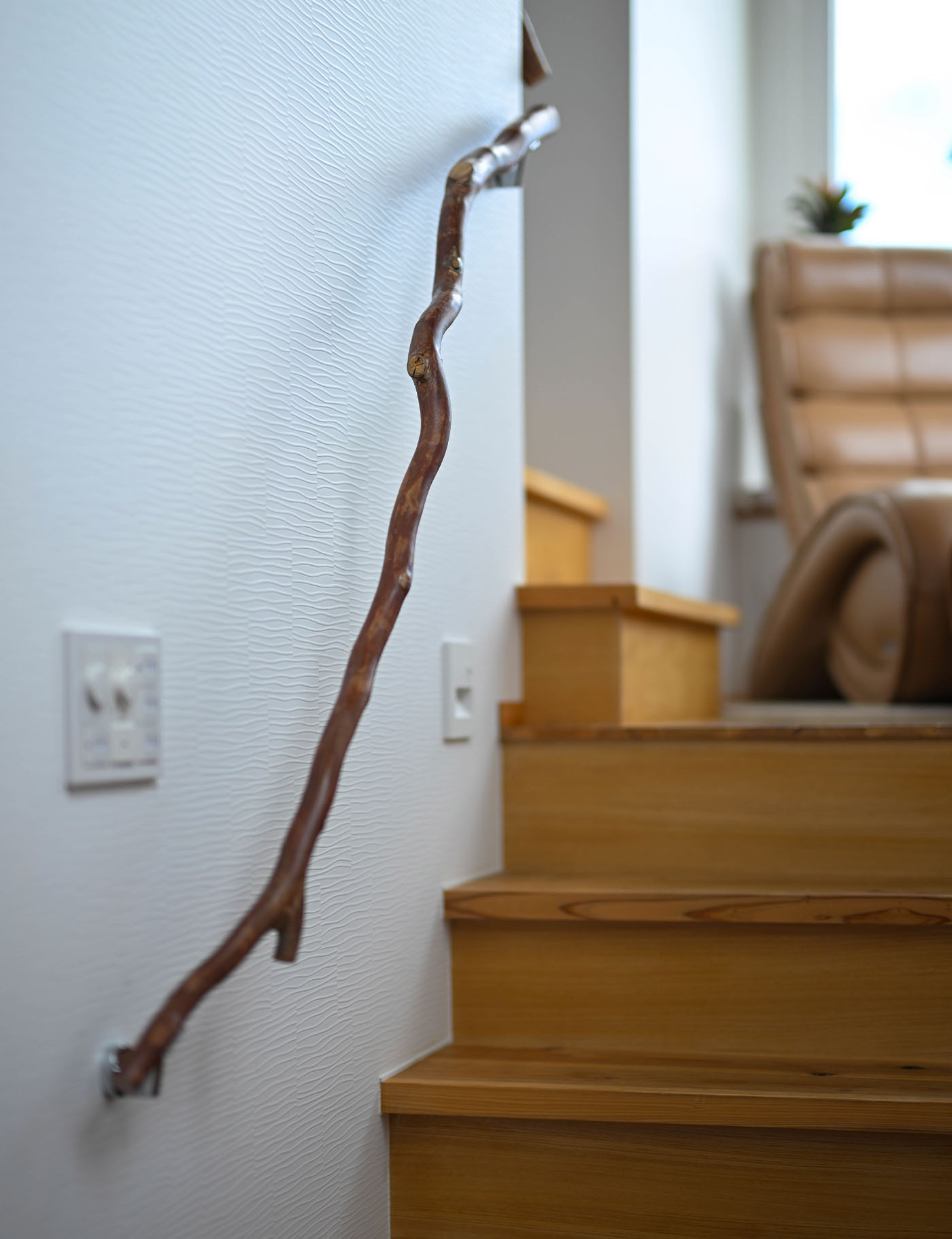階段には、設計者が用意した自然木の手すりを取り付けた。自然のままの曲線が空間にも手にもしっくりとなじむ