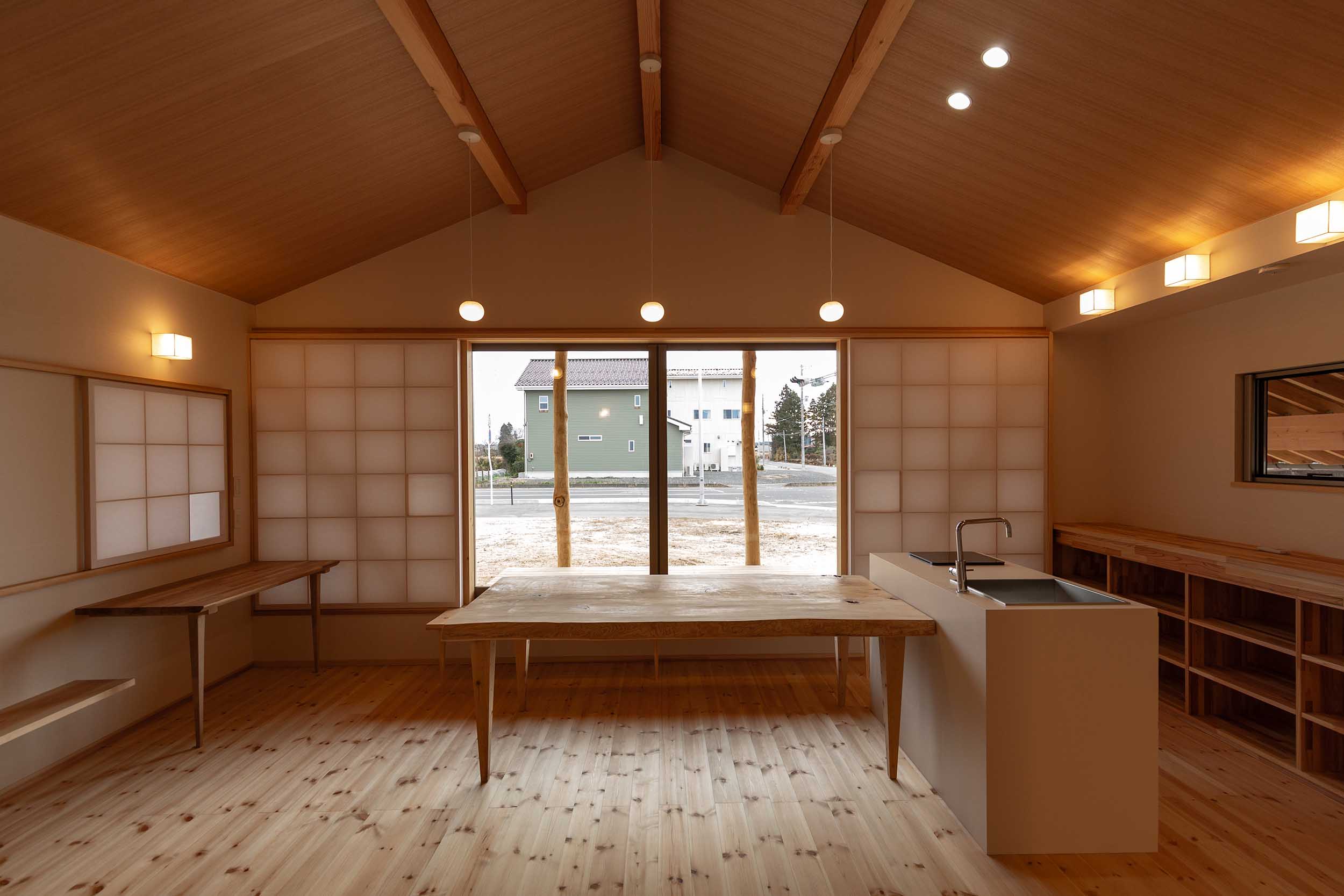 勾配の緩やかな三角の天井に、障子と木と淡い小さな照明。住む人に安らぎを与える。
